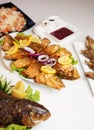 Fried fish with vegetable on white dish. Tasty and spicy fish fry