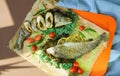 Fried fish with vegetables on colourful background. Lemons, tomatos, pepper, seafood dish. Healthy lifestyle. Restaurant menu.