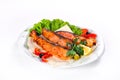 Fried fish with vegetables on a plate on a white isolated background Royalty Free Stock Photo