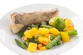 Fried fish with vegetables on a plate, vegetables wok, white background Royalty Free Stock Photo