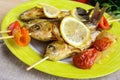 Fried fish (carp) on skewers with pieces bell pepper, sun-dried tomatoes and lemon. Royalty Free Stock Photo