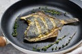 Fried flounder in a pan. Gray background, top view. Royalty Free Stock Photo