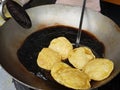 Fried food kachauri puri pile deep fried in oil in a big steel frying pan