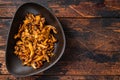 Fried forest chanterelle mushrooms with herbs. Wooden background. Top view. Copy space