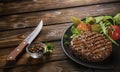 Fried fresh large beef burger with salad and herbs on black plate on wooden table