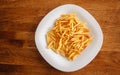 Fried fries on a white plate. Yummy French fries, a quick meal