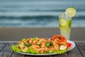 Fried frog legs with caipirinha cocktail with the beach in the background Royalty Free Stock Photo