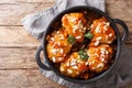 Fried glazed chicken thighs with dried apricots and almonds closeup in a pan. Horizontal top view