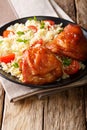 Fried glazed chicken thighs with rice, greens and tomatoes on a