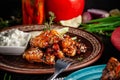 Fried glazed chicken wings in soy sauce and sesame. Cheese white sousa. Marinated vegetables on a ceramic plate. Background image