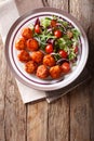 fried glazed meatballs served with salad of lettuce, cherry tomatoes and onions close-up on a plate. Vertical top view