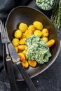 Fried gnocchi potato pasta with spinach. Black background. Top view Royalty Free Stock Photo
