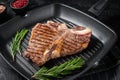 Fried on a grill skillet t bone porterhouse beef meat Steak. Black background. Top view