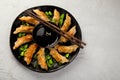 Fried gyoza dumplings with soy sauce and onion on light gray background
