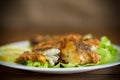 Fried hake fish in batter with lettuce and lemon in a plate