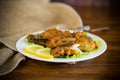 Fried hake fish in batter with lettuce and lemon in a plate