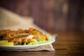 Fried hake fish in batter with lettuce and lemon in a plate