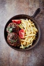 Fried hamburger steaks with tomatoes and french fries. Royalty Free Stock Photo