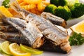 Fried herrings, chips and vegetables Royalty Free Stock Photo