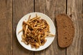 Fried honey mushrooms on a plate with a piece of black bread on an old wooden table, fried mushrooms at home Royalty Free Stock Photo