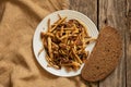 Fried honey mushrooms on a plate with a piece of black bread on an old wooden table, fried mushrooms at home Royalty Free Stock Photo