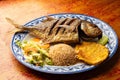 Fried horse mackerel fish with coconut rice, patacon and vegetable salad Royalty Free Stock Photo