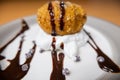 Fried ice cream with cream, chocolate syrup and chips on plate Royalty Free Stock Photo