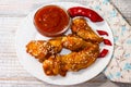 Fried juicy chicken wings marinated with honey, soy sauce, spices, sprinkled with sesame seeds on a white plate with sauce. Asian Royalty Free Stock Photo