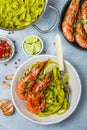 Fried king prawns with garlic, pepper, lime and parsley cilantro. Large shrimp. Langoustine. Delicious dinner with pasta tagliat