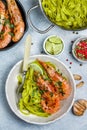 Fried king prawns with garlic, pepper, lime and parsley cilantro. Large shrimp. Langoustine. Delicious dinner with pasta tagliat Royalty Free Stock Photo