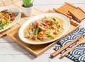 Fried large intestine with shredded ginger served in a dish isolated on wooden tray and napkin side view of taiwan food