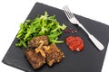 Fried liver, fresh arugula on black stone plate