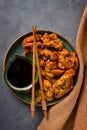 Fried meat in batter, deep-fried, with sesame seeds, and soy sauce, on a gray table, there are no people, Royalty Free Stock Photo