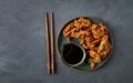 Fried meat in batter, deep-fried, with sesame seeds, and soy sauce, on a gray table, there are no people, Royalty Free Stock Photo