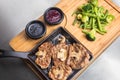 Fried meat with mushrooms, sauses and vegetables on wooden plate Royalty Free Stock Photo