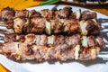 The fried meat with onion on the metal skewers on the plate. Shish kebab, bbq, pork Royalty Free Stock Photo