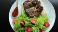 Fried meat and spicy sauce served on plate with lettuce leaves and thin bread Royalty Free Stock Photo