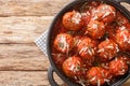 Fried meatballs with parmesan and then stewed in spicy tomato sauce close-up in a frying pan. Horizontal top view Royalty Free Stock Photo