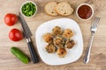 Fried meatballs in plate, tomatoes, cucumbers, condiments and fork Royalty Free Stock Photo