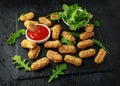 Fried mozzarella cheese sticks in breadcrumbs with ketchup sauce and wild rocket leaves Royalty Free Stock Photo