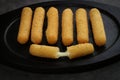 Fried mozzarella sticks crispy on a black woden plate isolated - close up Royalty Free Stock Photo