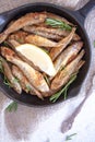 Fried mullet with rosemary and lemon in a pan