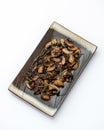 Fried mushroom slices and thyme on platter. Rectangular Clay plate with cooked champignons isolated on white background Royalty Free Stock Photo