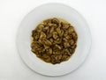 Fried mushrooms, Funghi trifolati, in a white dish isolated on white background