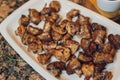 Fried mushrooms, Funghi trifolati, in a white dish isolated on white background.