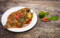 Fried Nile tilapia fish with red curry paste on white plate wooden background, Thai food is spicy mixed with sweet flavor with Royalty Free Stock Photo