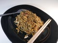 Fried noodles with a messy look that will be eaten using chopsticks and forks.