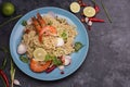 Fried noodles put in a blue plate ready to serve With lime shrimp lemongrass shallot coriander spring onion and chili on a black Royalty Free Stock Photo