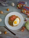 Fried noodles served with fried egg. Food flat lay concept. From top view on wood background