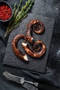 Fried octopus tentacles with thyme and pink pepper. Fresh seafood. Black background. Top view Royalty Free Stock Photo